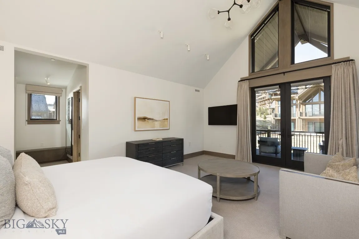 Bedroom with access to outside, carpet, and high vaulted ceiling