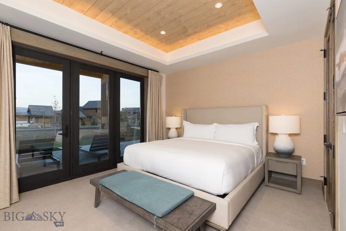 Bedroom with french doors, a tray ceiling, access to outside, light carpet, and wood ceiling