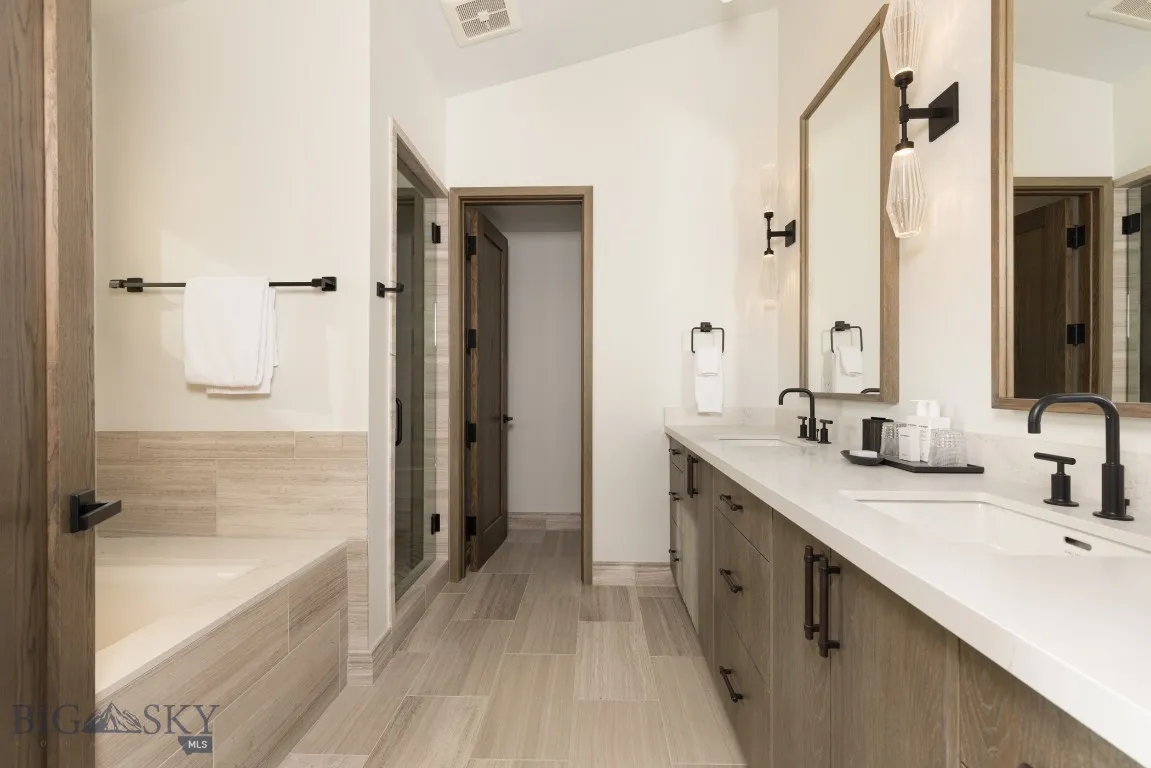Bathroom featuring vanity, shower with separate bathtub, and vaulted ceiling