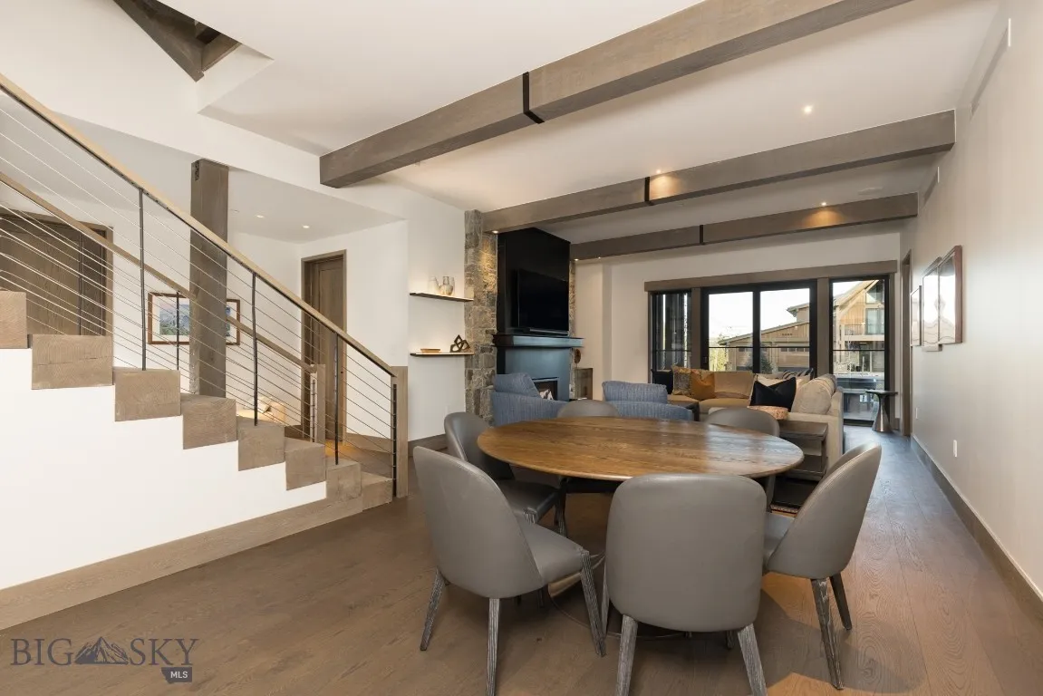 Dining space with beamed ceiling, a fireplace, and dark wood-type flooring