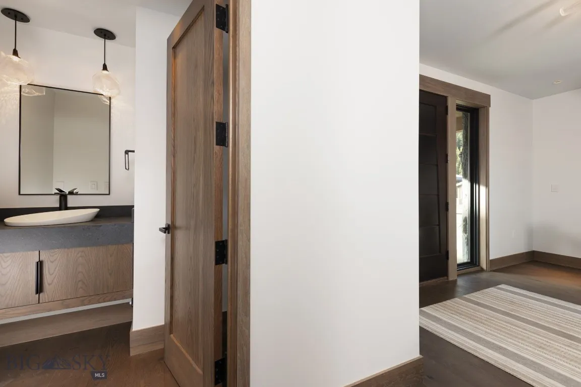 Hall featuring dark wood-type flooring and sink