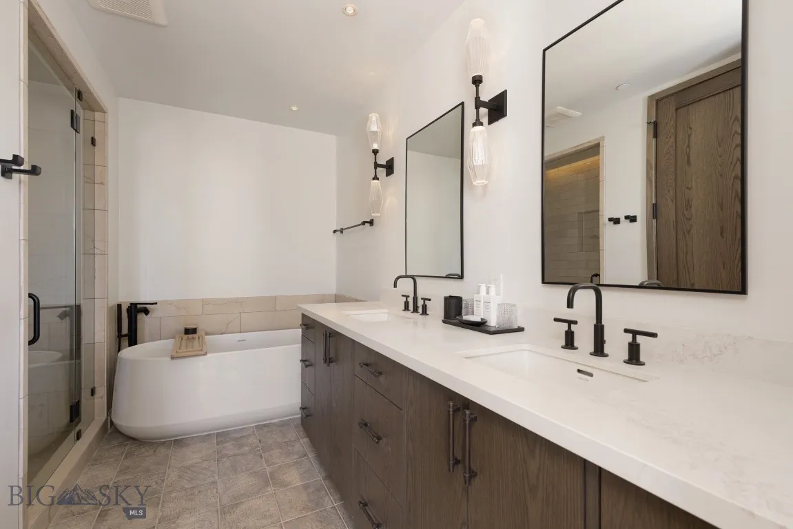 Bathroom featuring plus walk in shower, tile patterned flooring, and vanity