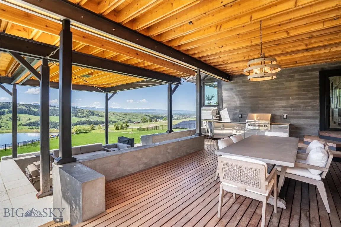 Covered patio with mahogany decking, outdoor kitchen with built-in grill and pizza oven