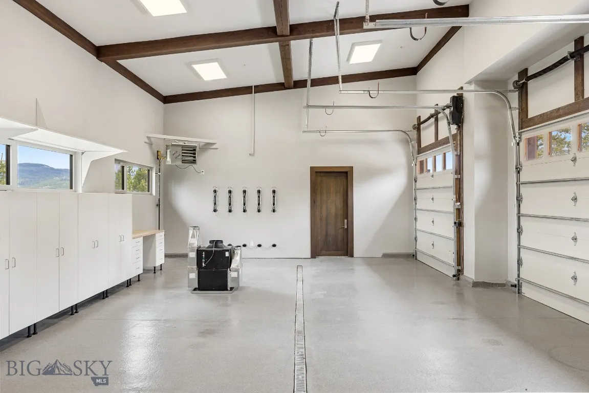 Garage detail- lots of light, floor drain, and door access to ski store room. There is also a dog bath in the garage!