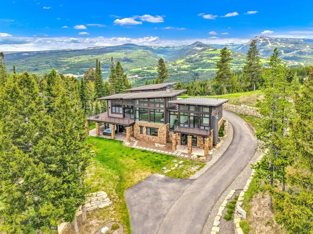 Driveway approach with Yellowstone Club views prominently featured from the west side of the home.