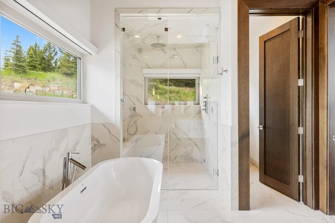 Primary bedroom ensuite bathroom with heated marble floor, dual vanity, walk in shower, frees standing tub