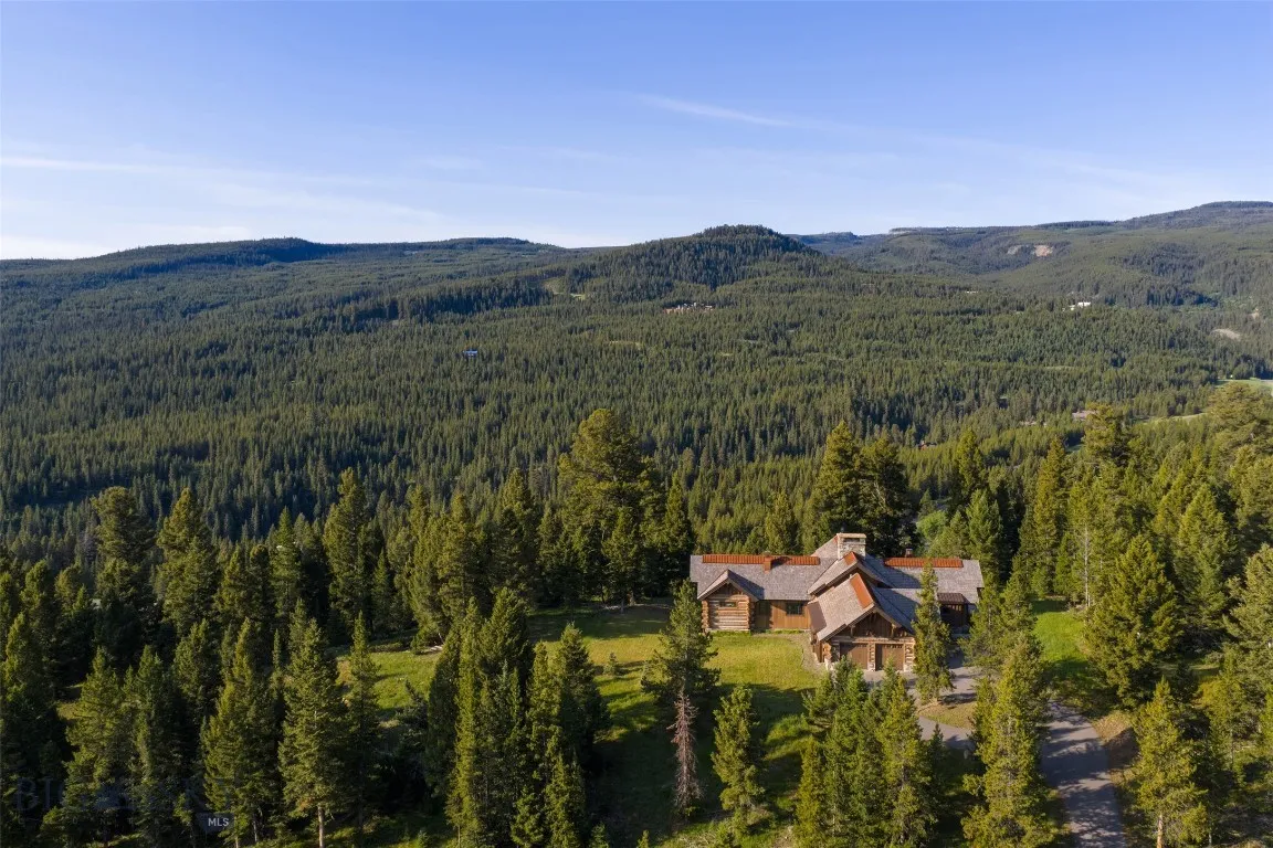 Aerial views showcase this exceptional mountain estate tucked into a private forested setting, with breathtaking scenery, winding roads, and stunning alpine surroundings—just minutes from world-class amenities.