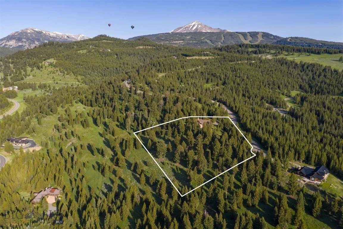 Aerial views showcase this exceptional mountain estate tucked into a private forested setting, with breathtaking scenery, winding roads, and stunning alpine surroundings—just minutes from world-class amenities.