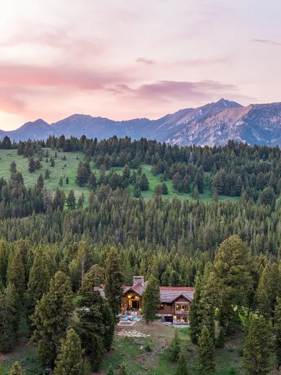 Aerial views showcase this exceptional mountain estate tucked into a private forested setting, with breathtaking scenery, winding roads, and stunning alpine surroundings—just minutes from world-class amenities.