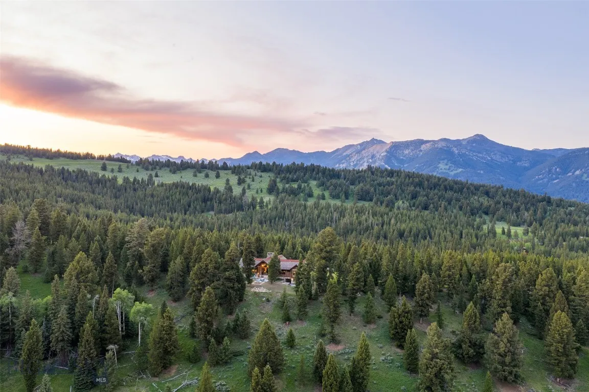 Aerial views showcase this exceptional mountain estate tucked into a private forested setting, with breathtaking scenery, winding roads, and stunning alpine surroundings—just minutes from world-class amenities.