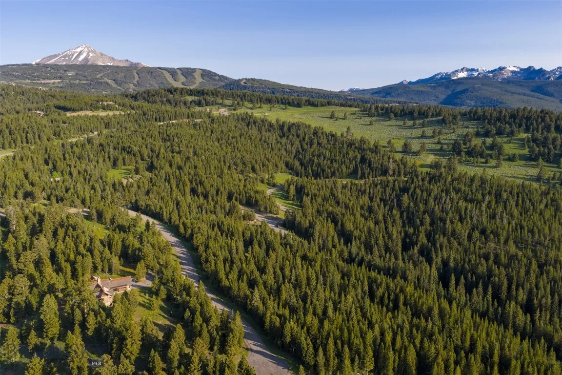 Aerial views showcase this exceptional mountain estate tucked into a private forested setting, with breathtaking scenery, winding roads, and stunning alpine surroundings—just minutes from world-class amenities.
