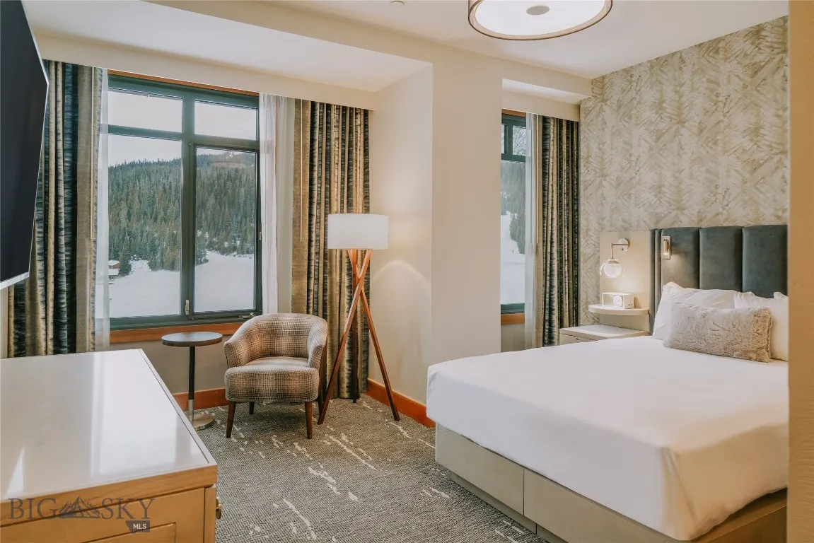 Comfortable bedroom with natural light and mountain views.