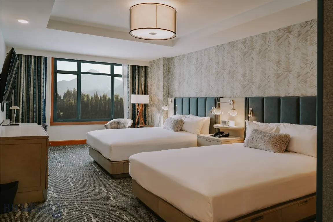 Spacious guest suite with double queen beds and refined mountain décor