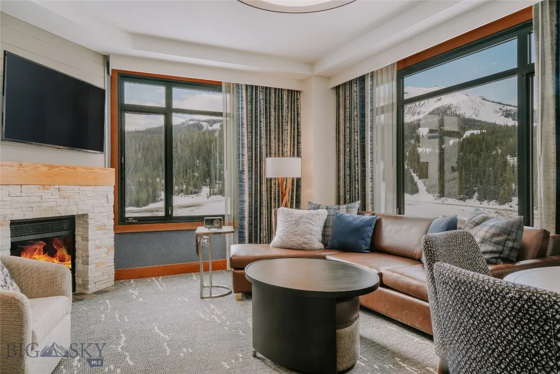 Spacious living area with gas fireplace, large windows, and stunning mountain views.
