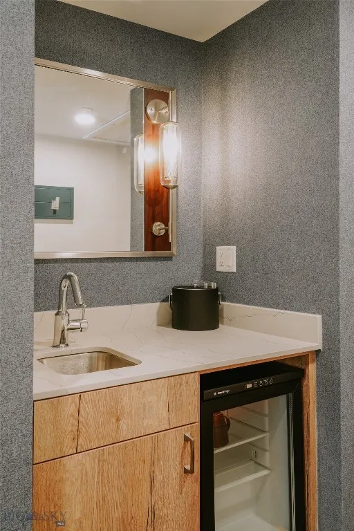 Wet bar with under-counter refrigerator and quartz countertop for added guest convenience.