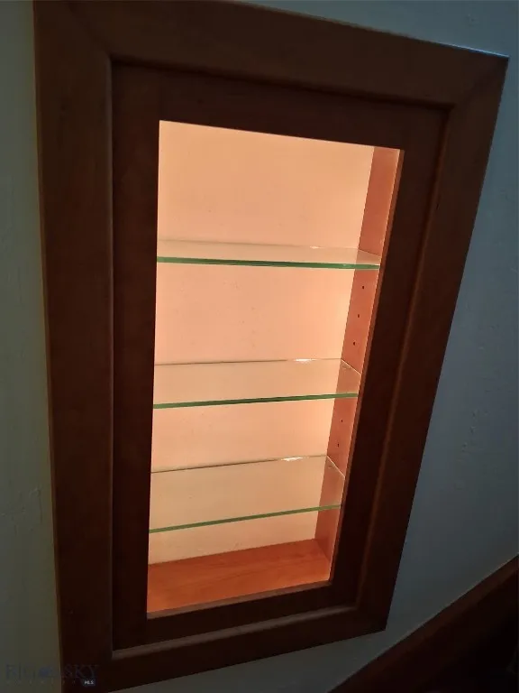 small solid cherry  cabinet, built into the stairwell wall:  lighted