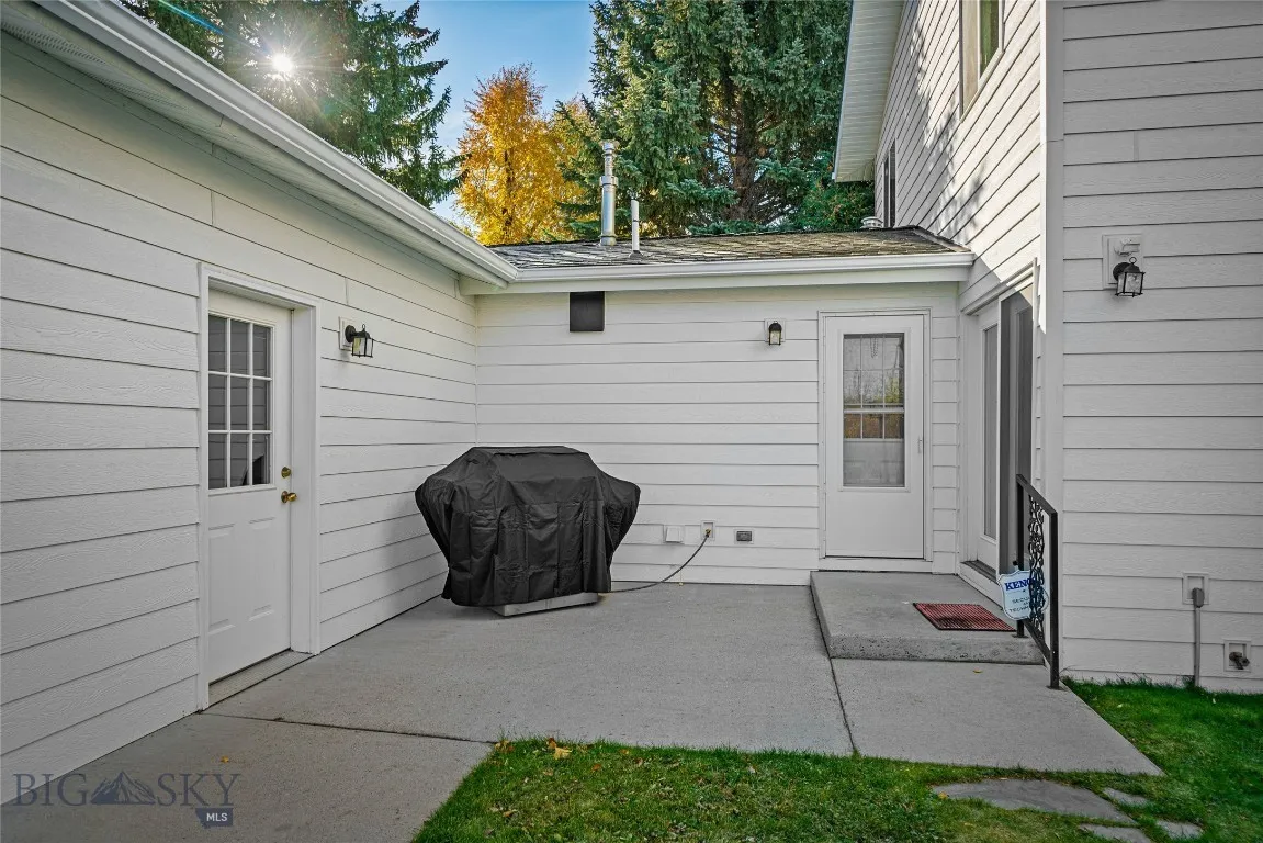 patio: garage on left, red patio door from kitchen on right