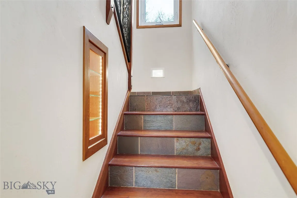 small solid cherry  cabinet, built into the stairwell wall:  lighted