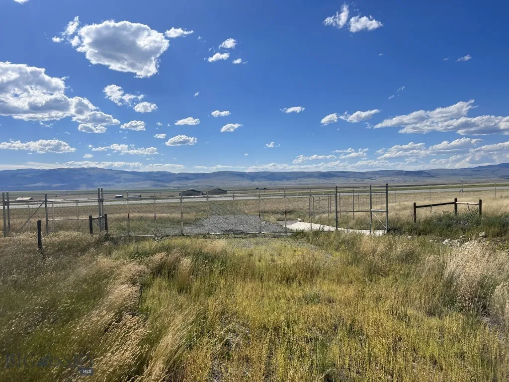 Gate bordering unimproved taxiway located at the end of the road.