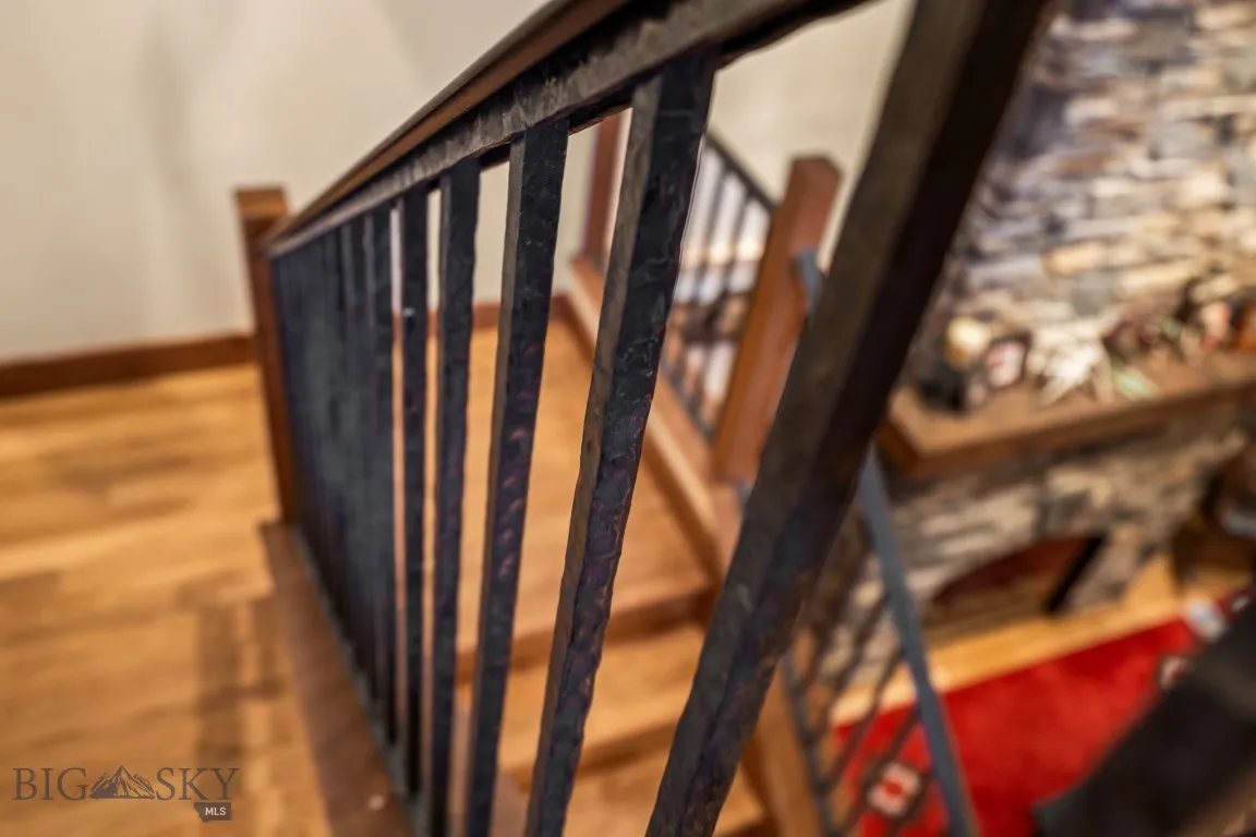 Stairway featuring hardwood and hand hammered railing