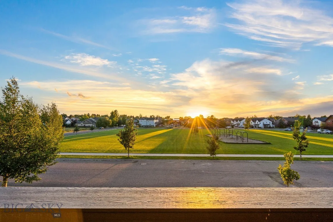 View from primary suite balcony of sun setting over the park