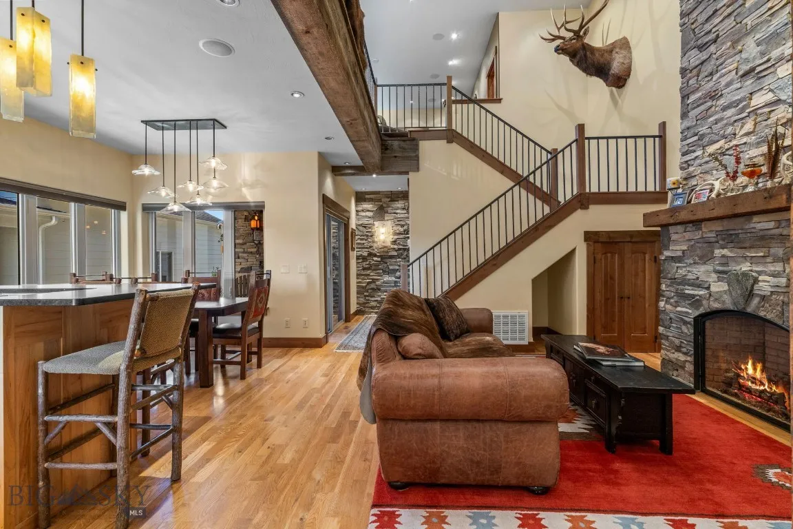 Open main living area with 2 story dry stack  fireplace, reclaimed lumber and stone accents