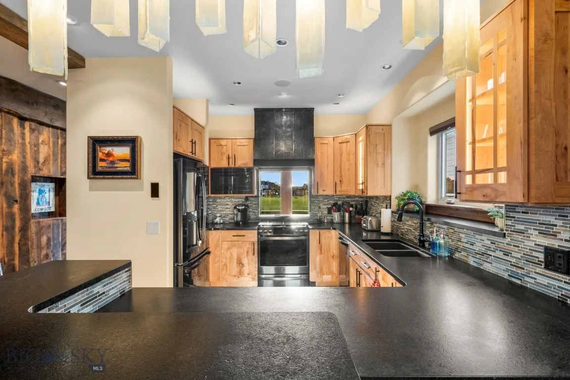 Kitchen with pot filler, custom range hood and view of entry and park