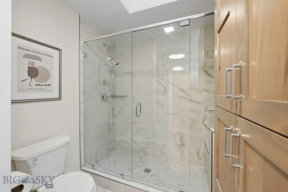 Spacious glass enclosed tiled shower