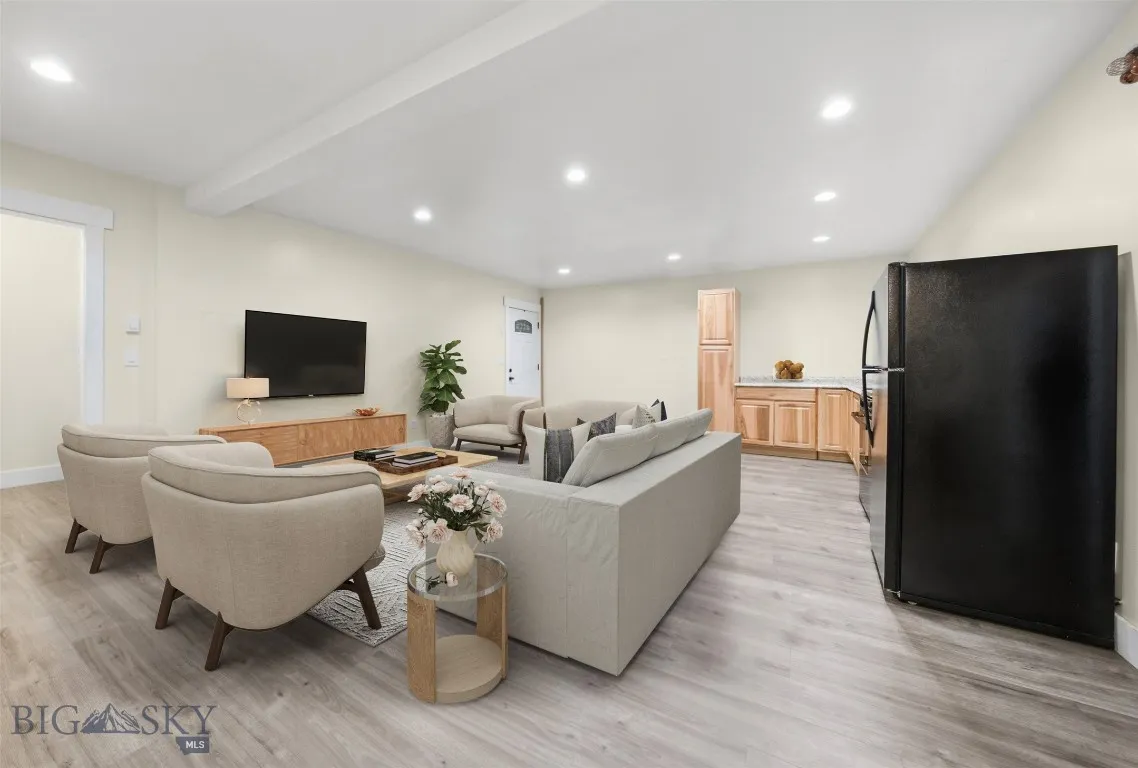 Basement living & kitchenette. This image has been virtually staged. Furniture and décor shown are for illustrative purposes only and do not convey.