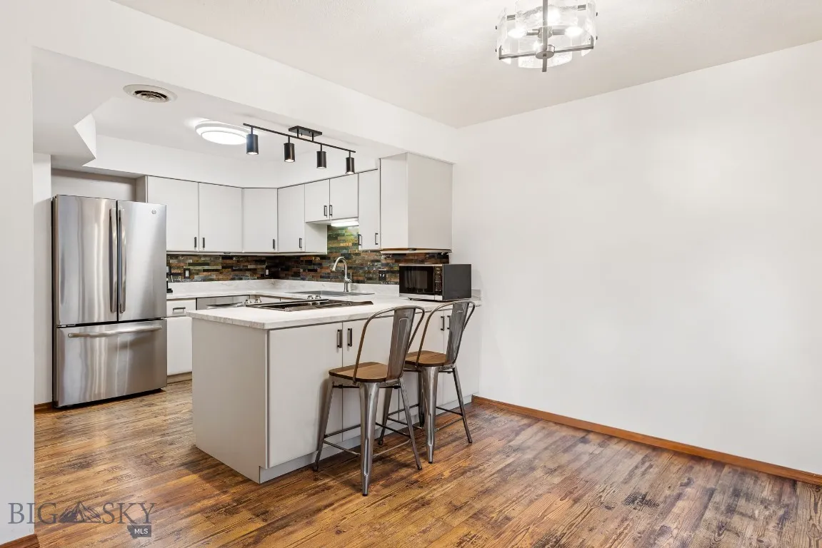 Open kitchen with updated appliances and lighting.