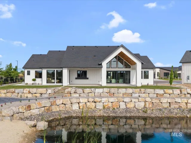 Modern farmhouse architecture featuring a white exterior with black trim accents and a dark shingle roof