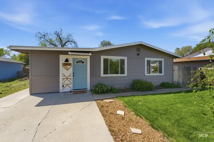 Single-story residence featuring a charcoal gray facade and a light blue entry door with a decorative half-moon window