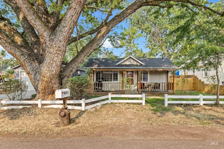Single-story home featuring a covered front porch with wood railings and a gable roofline