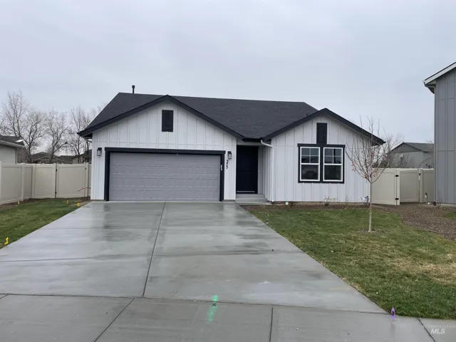 View of front facade featuring a shingled roof, board and batten siding, a gate, and concrete driveway