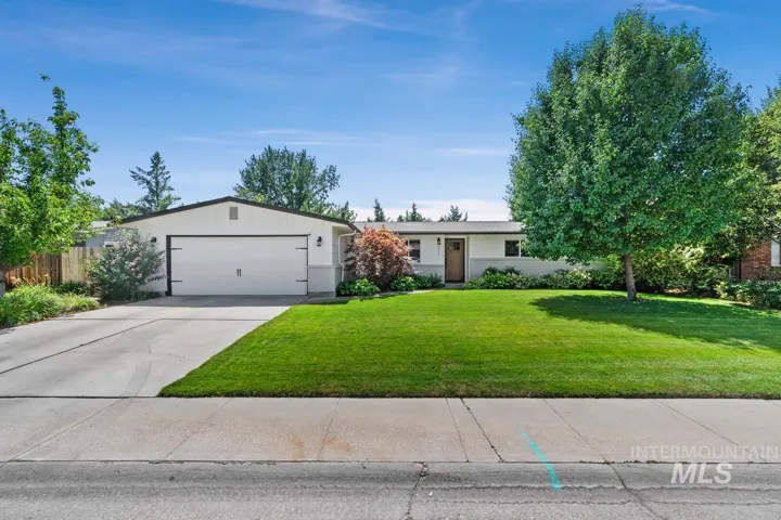 Single story home featuring concrete driveway, an attached garage, and brick siding