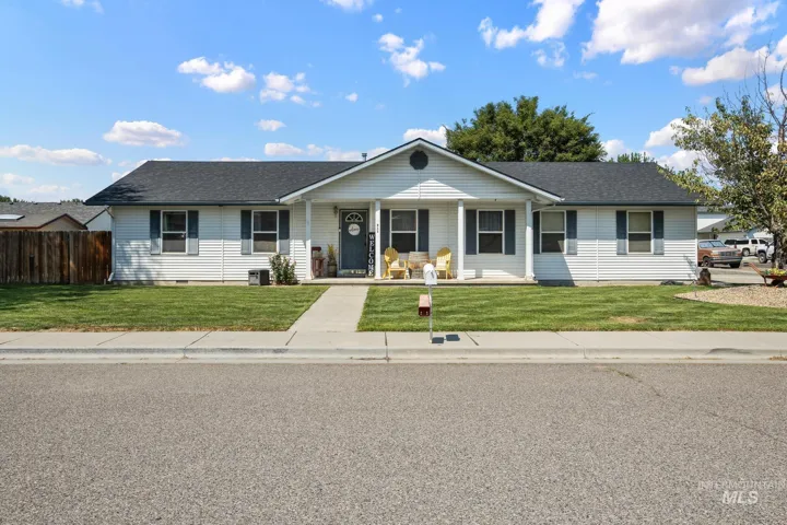 White siding exterior with a covered front porch, dark shingled roof, and a concrete walkway
