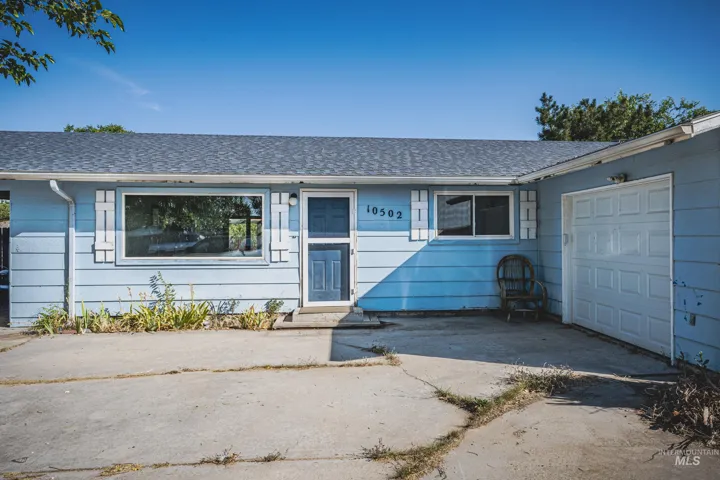 Light blue siding exterior with a dark blue entry door, white trim, and a shingled roof