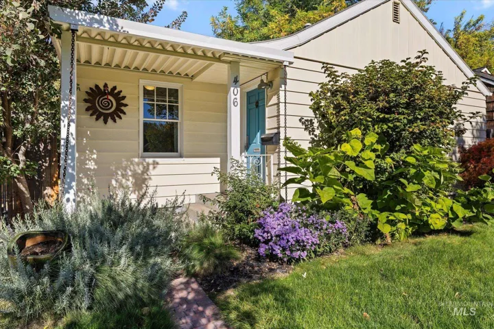 Exterior featuring horizontal siding, a covered front porch, a single-pane window, and a painted entry door