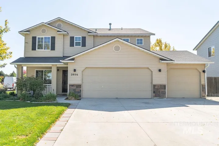 Two-story residence with a covered front porch, an attached three-car garage, and a concrete driveway