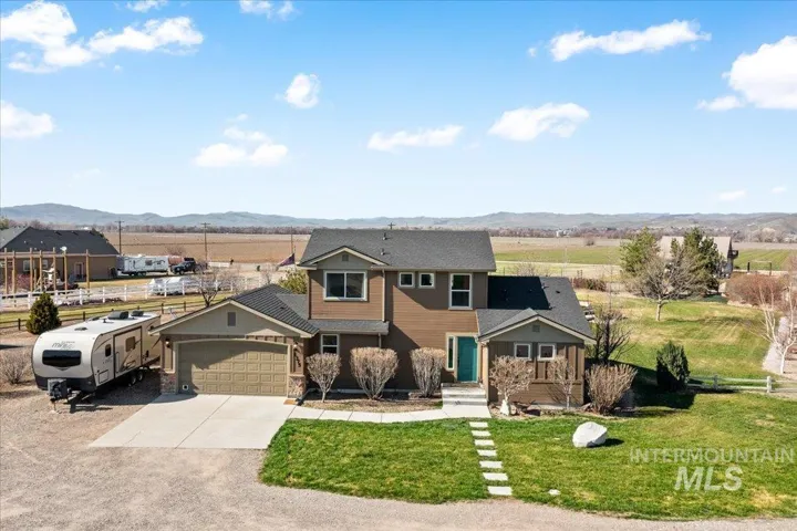 View of front facade featuring a mountain view, an attached garage, and driveway