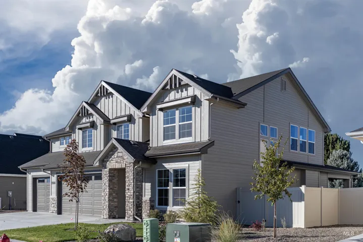 Multi-gabled exterior featuring horizontal siding, vertical board-and-batten accents, stone veneer entryway detail, and multi-pane windows