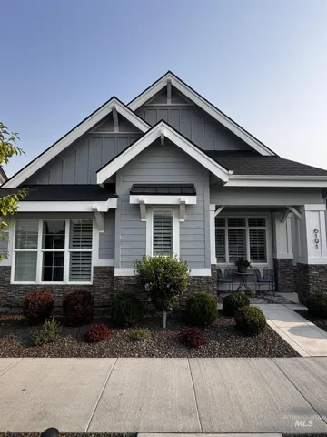 Contemporary home featuring a striking multi-gabled roofline with contrasting dark and light architectural details
