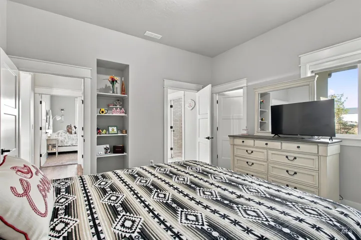 Light gray wall color, built-in shelving, white trim, recessed lighting, and a clear window