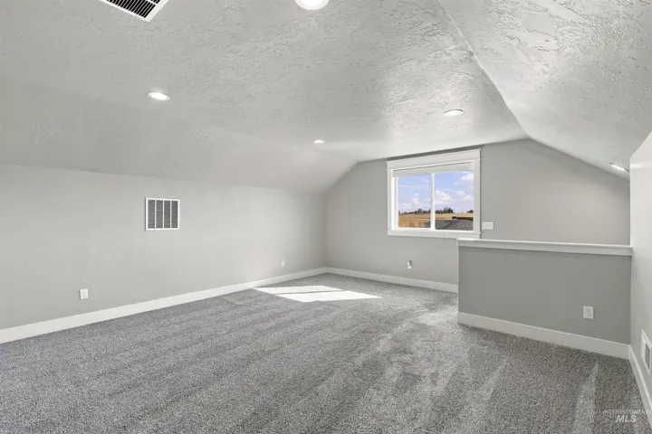 Carpeted room featuring a window, recessed lighting, and an architectural railing