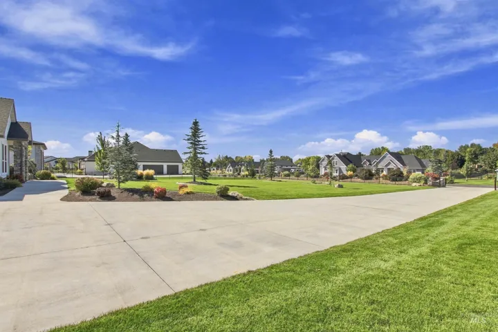 Expansive concrete driveway surrounded by manicured lawns and mature landscaping