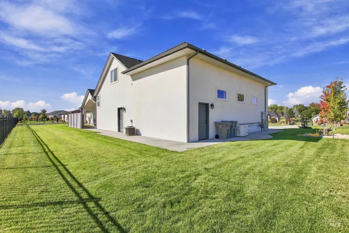 Expansive rear yard featuring a manicured lawn, full fencing, and a concrete patio