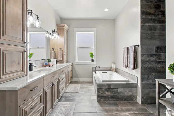 Dual vanity with light wood cabinetry, white countertops, and undermount sinks