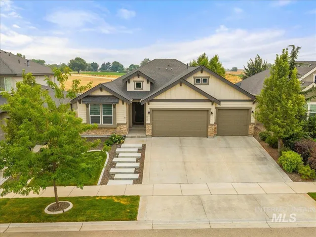 Craftsman-style exterior with stone veneer accents, multi-pane windows, and a two-car garage