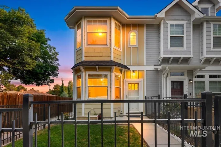 Two-story exterior featuring bay windows, arched accent window, and a gabled roofline