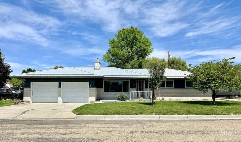 Ranch-style residence featuring a light gray brick facade and metal roof